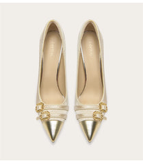 Pair of gold pointed-toe shoes with decorative straps on a white background