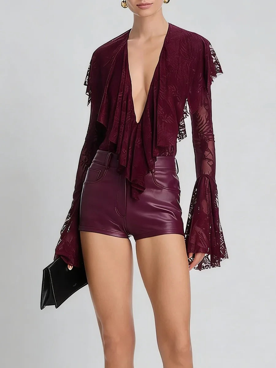 Person wearing a burgundy outfit with a deep neckline and high-waisted shorts on a light gray background