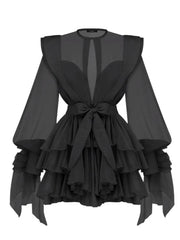 Black dress with ruffled layers and sheer sleeves on a white background