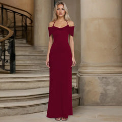 Woman in a burgundy evening gown standing in an elegant interior setting.