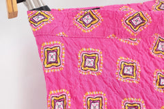 Pink quilt with decorative patterns on a white background
