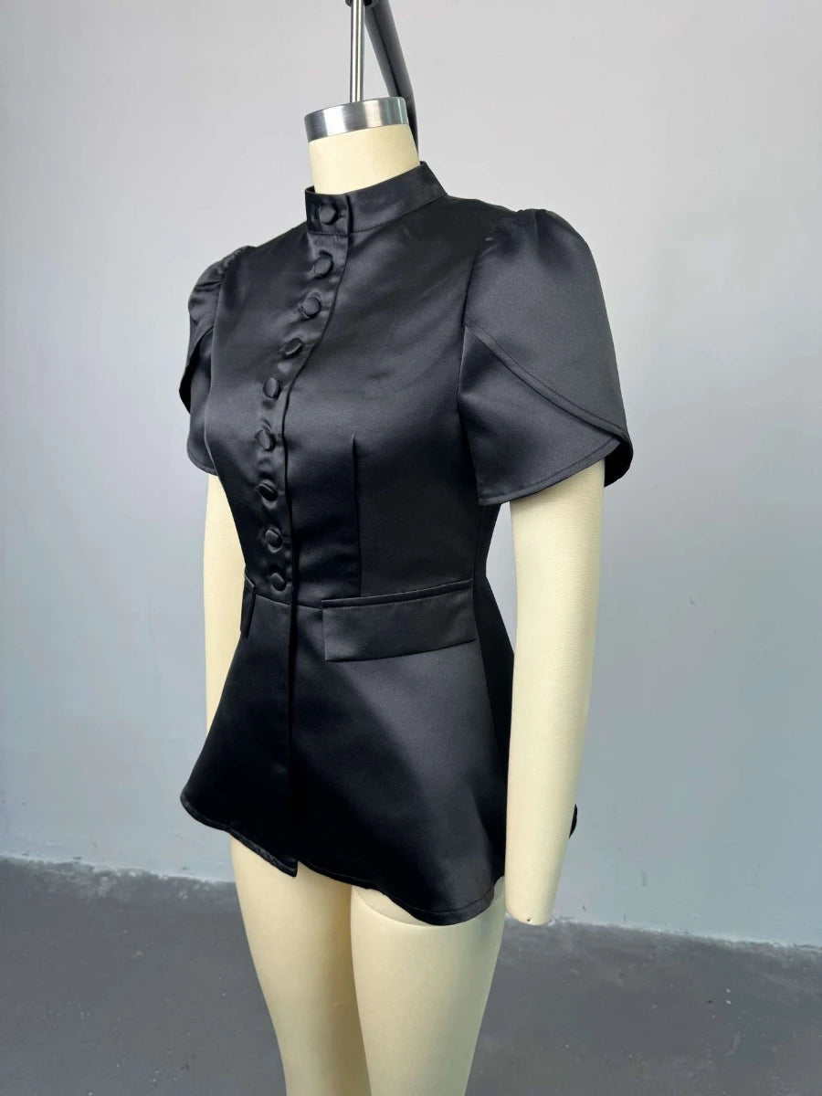 Black leather top on a mannequin against a gray background