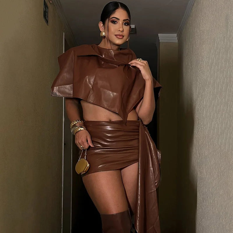 Woman wearing a brown leather outfit in a dimly lit room.