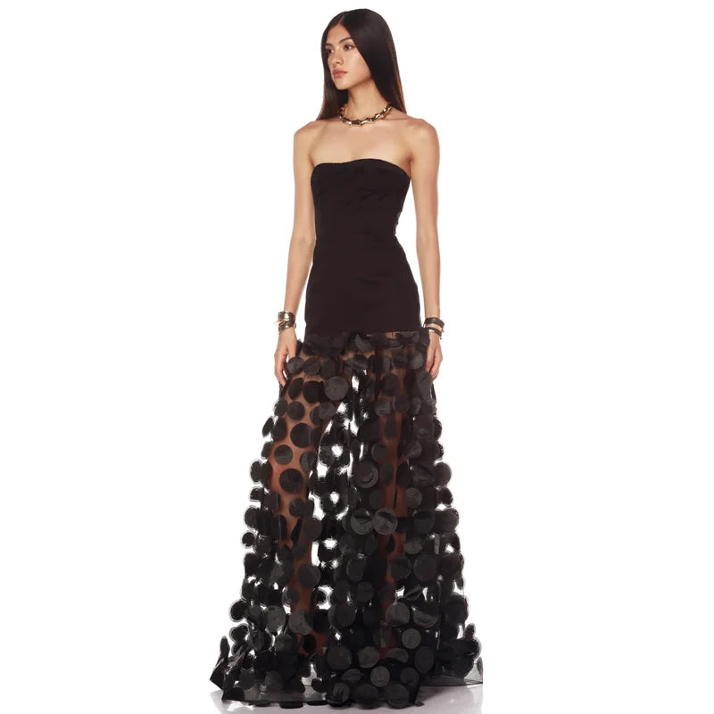 Strapless black maxi dress with dimensional floral appliques on skirt, angled view
