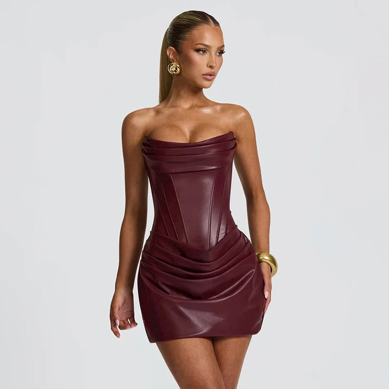 Woman wearing a strapless burgundy dress against a plain background