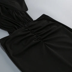 Close-up detail of the ruched waist on a black maxi dress