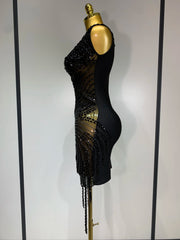 Black beaded dress on a mannequin against a plain background