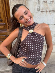 Woman wearing a polka dot top with a brick wall background