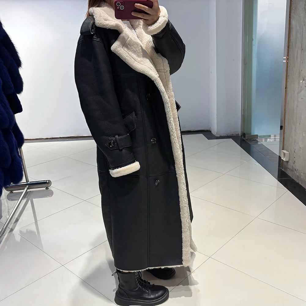 Person wearing a black coat with white fur lining in a room.