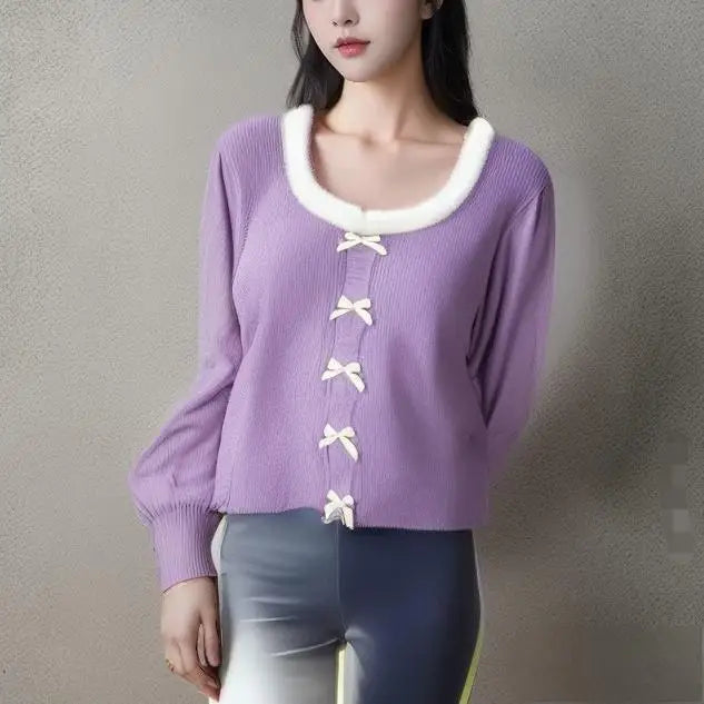 Person wearing a purple sweater with white trim and buttons against a gray background