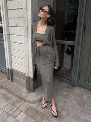 Woman in a green outfit standing outside a building