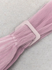 Pink textured belt with a buckle on a light gray background