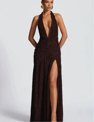 Woman wearing a brown halter neck dress with a high slit