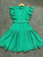 Green dress with ruffled sleeves and a belt on a gray background
