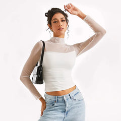 Woman wearing a white top with sheer sleeves and blue jeans on a white background