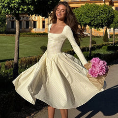 Woman in a white dress holding pink flowers in an outdoor setting