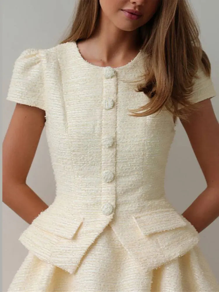 White textured dress with buttons on a plain background