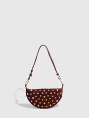 Maroon handbag with gold studs on a light gray background