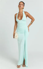 Woman wearing a mint green halter neck gown on a white background