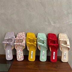 Set of colorful sandals with a brand label on a wooden surface and gray background