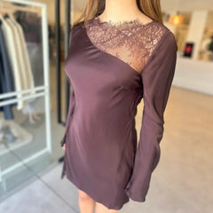 Purple dress with lace detailing worn by a person in a store setting