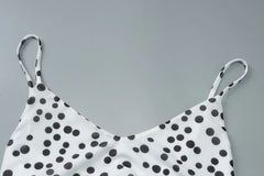 White top with black polka dots on a gray background