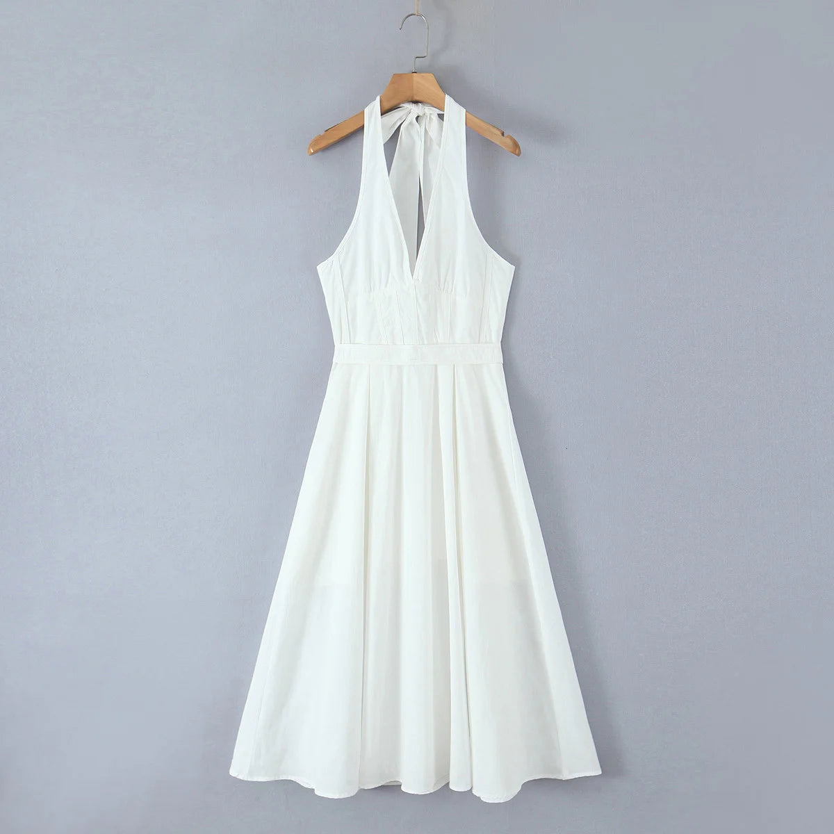 White dress on a hanger against a gray background