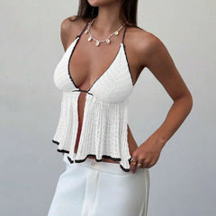 White crochet top with black trim worn by a person on a plain background