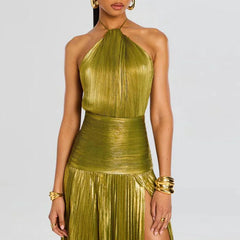 Woman wearing a gold metallic dress with a plain background