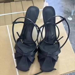Black satin stiletto heels with bow detail and ankle straps