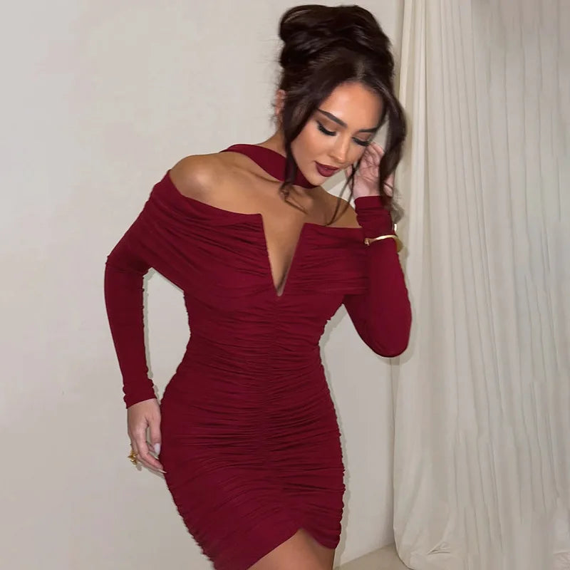 Woman wearing a burgundy off-shoulder dress against a neutral background