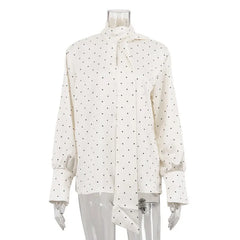 White blouse with black polka dots on a mannequin against a white background