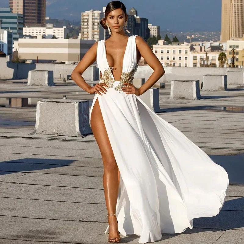 Woman in a white gown with gold accents on a rooftop with cityscape background