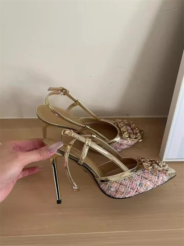 Gold high-heeled shoes with floral pattern on a wooden surface