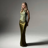 Woman wearing a green evening gown against a gray background