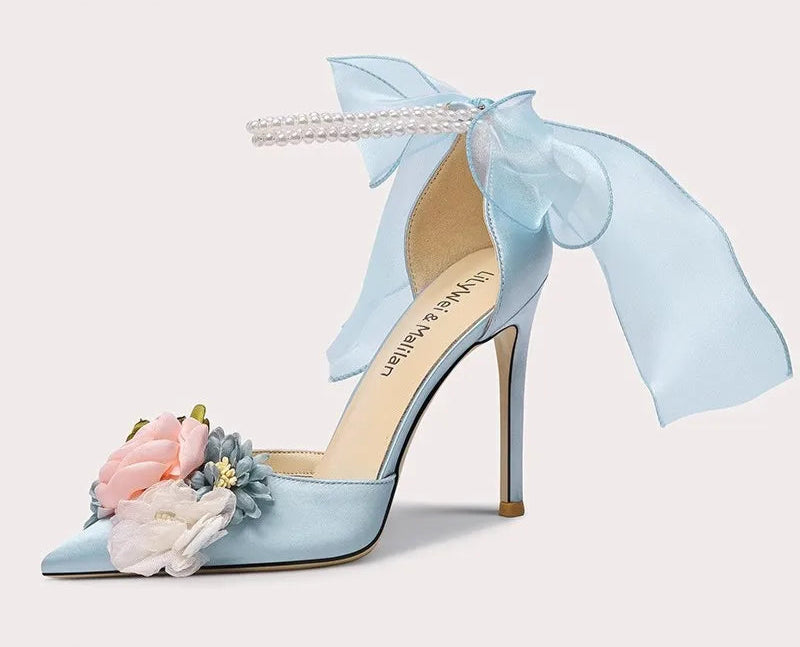 Light blue high-heeled shoe with floral decorations on a white background