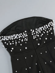 Black strapless top with pearl embellishments on a gray background