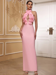 Woman wearing a pink dress with floral details in an elegant indoor setting.