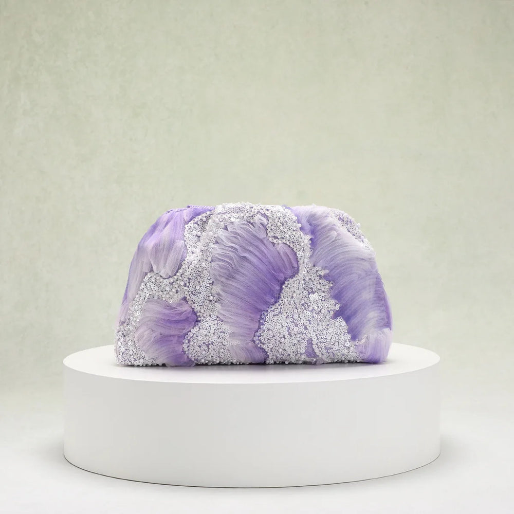 Purple and white textured object on a white pedestal against a light gray background