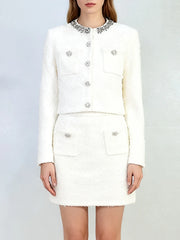 White outfit with decorative buttons on a plain background