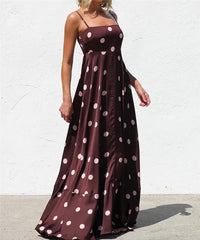 Model posing in a polka dot satin maxi dress