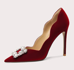 Red high-heeled shoe with decorative bow on a white background
