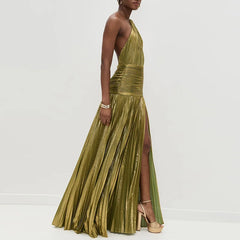 Woman wearing a green pleated dress with a slit on a white background