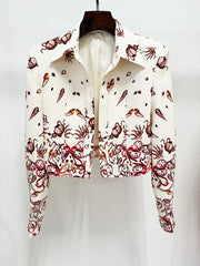 Close-up of a white cropped jacket with a sea world print, hung on a hanger.