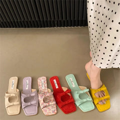 Colorful slides on a neutral floor with a person wearing one slide.