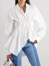 White blouse with a tie front and blue jeans on a white background