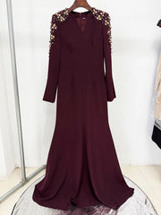 Maroon dress with floral embellishments on shoulders on a white background