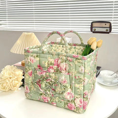 Floral patterned tote bag on a table with flowers and a lamp in the background