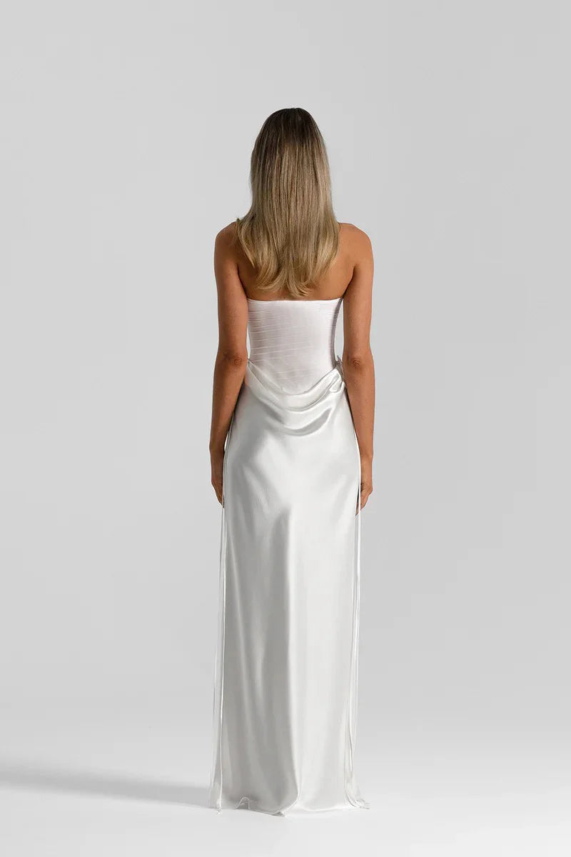 Woman wearing a white strapless gown on a plain background