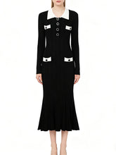 Black dress with white collar and buttons on a white background